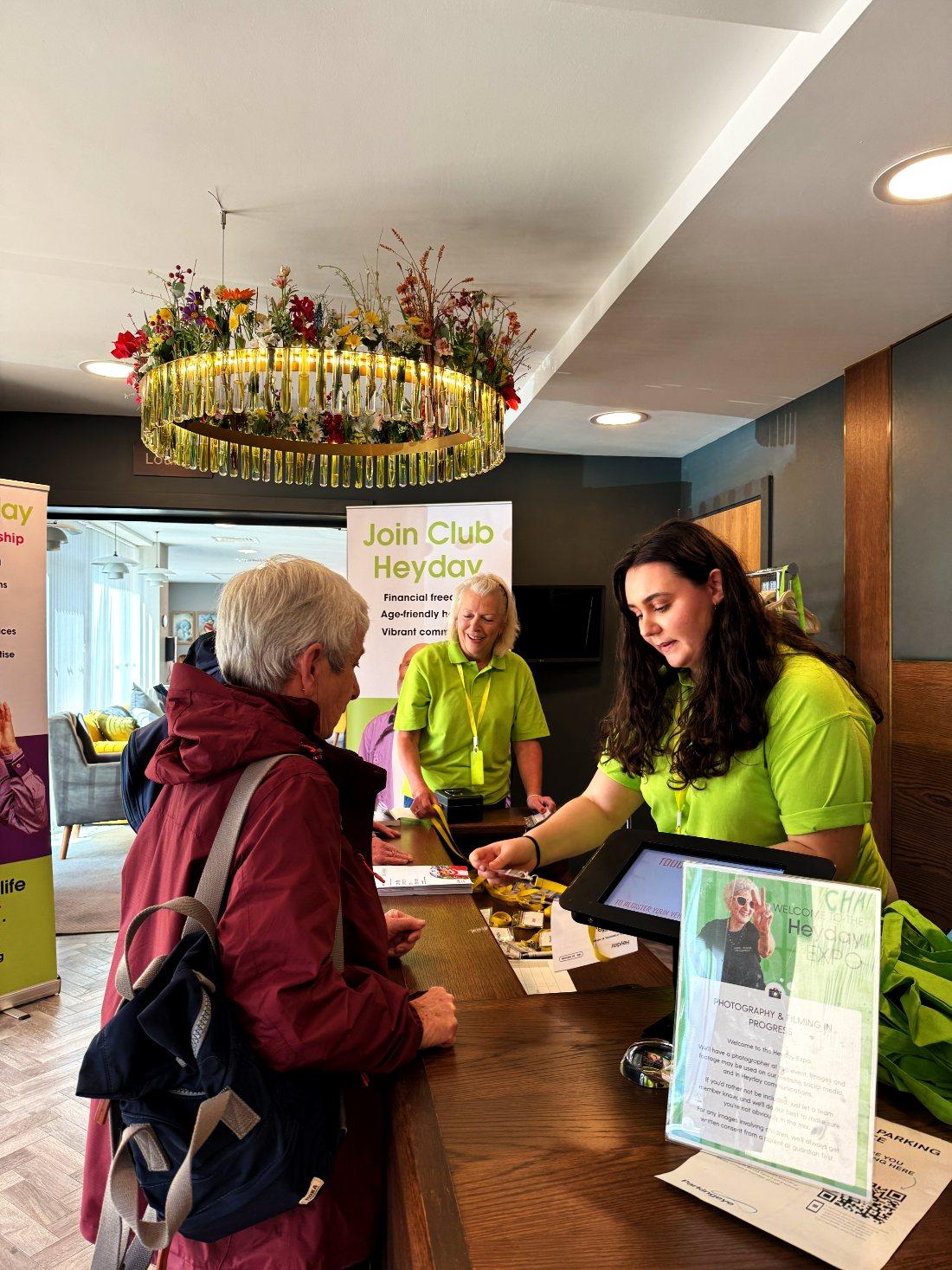 Members being welcomed at the registration desk under the flower chandelier