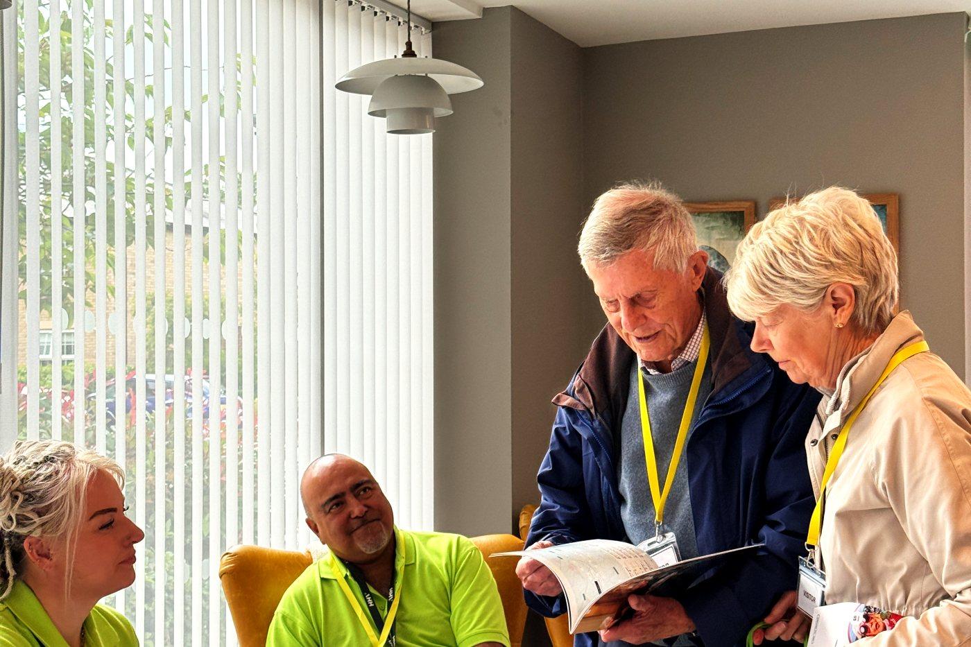 Two visitors reading a brochure together at one of the zone tables
