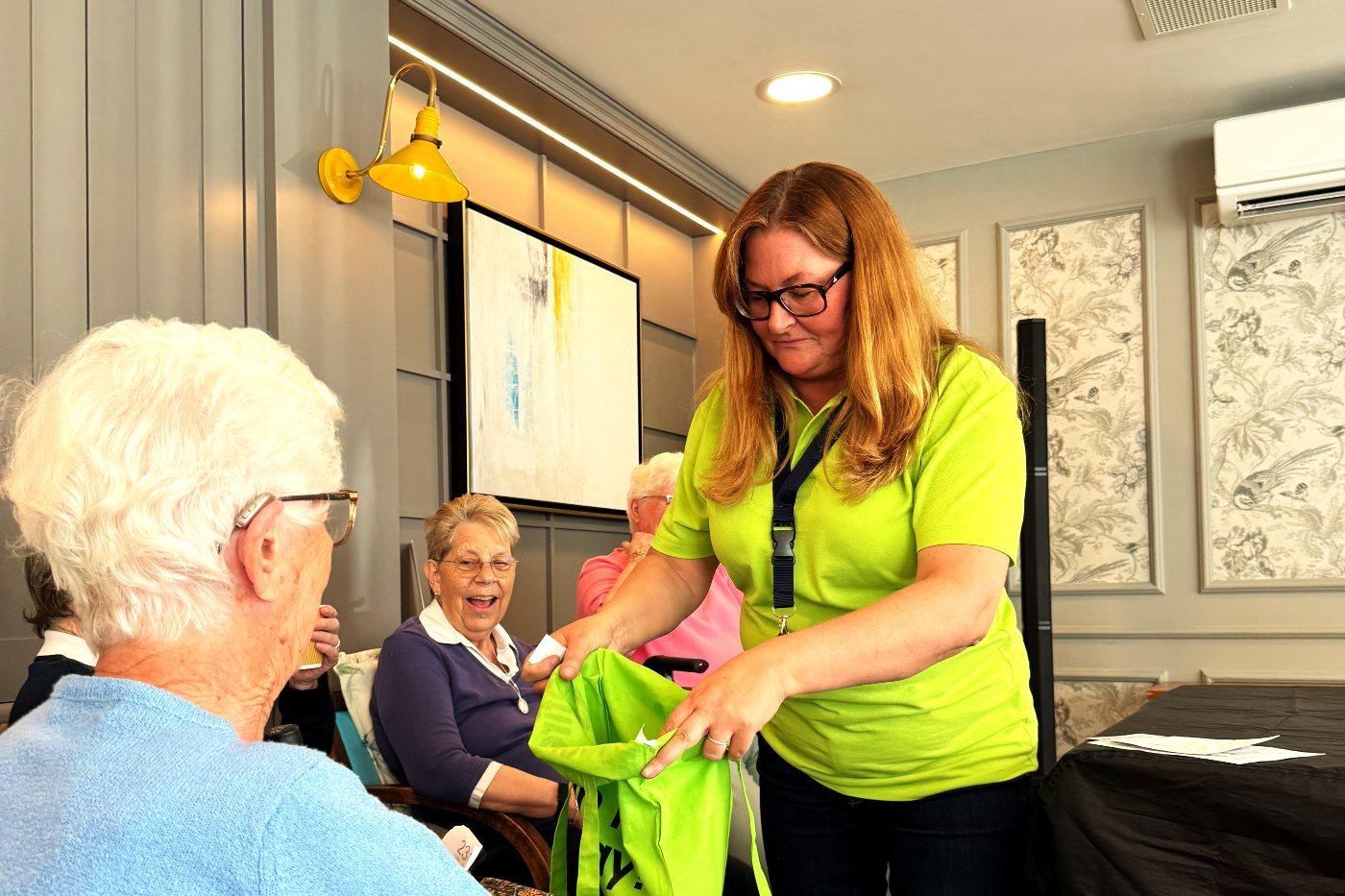 A Heyday team member handing a raffle prize to a delighted winner